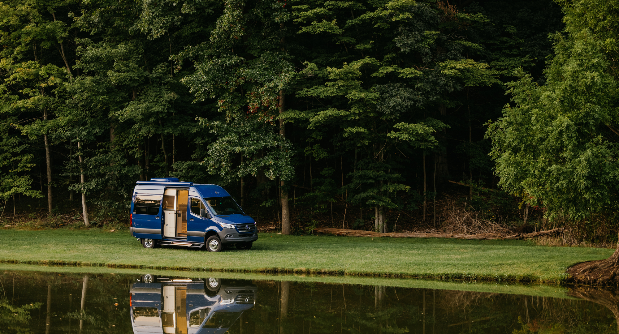 Custom Class B motorhome parked by mountain lake – Advanced RV